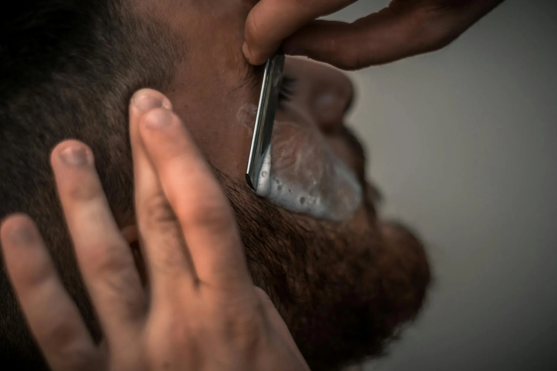 person holding gray straight razor