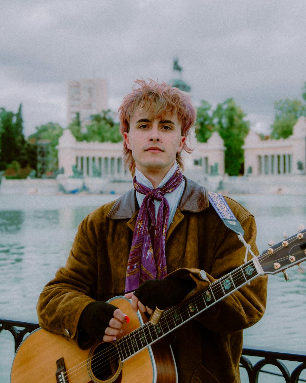 man with a guitar on a bridge