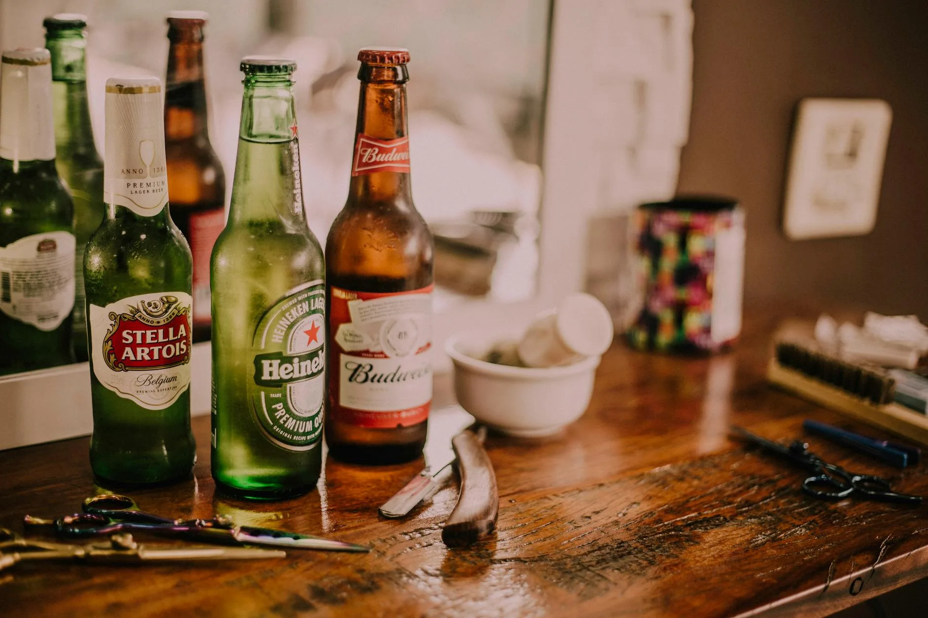 three assorted beverage bottles on brown wooden table