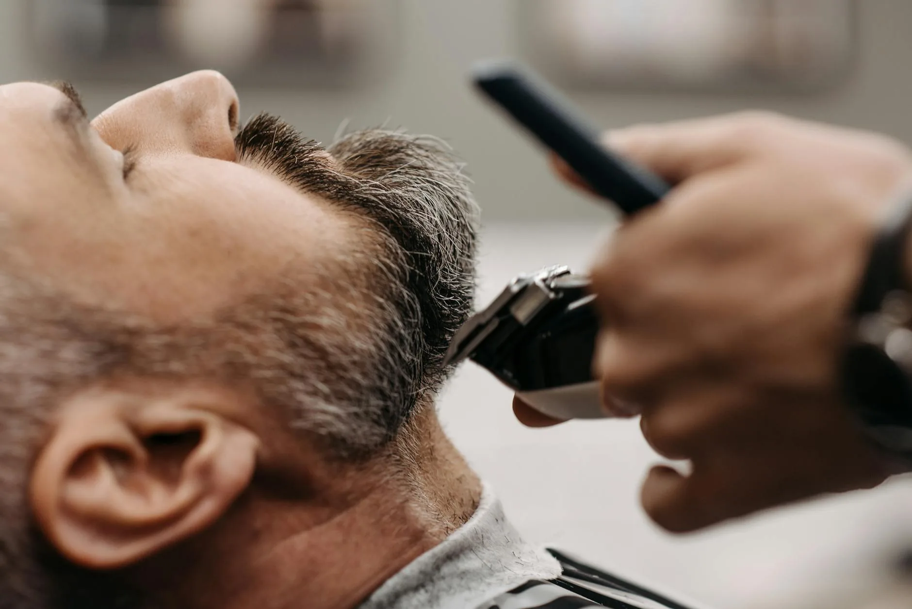 a barber cutting a client s beard