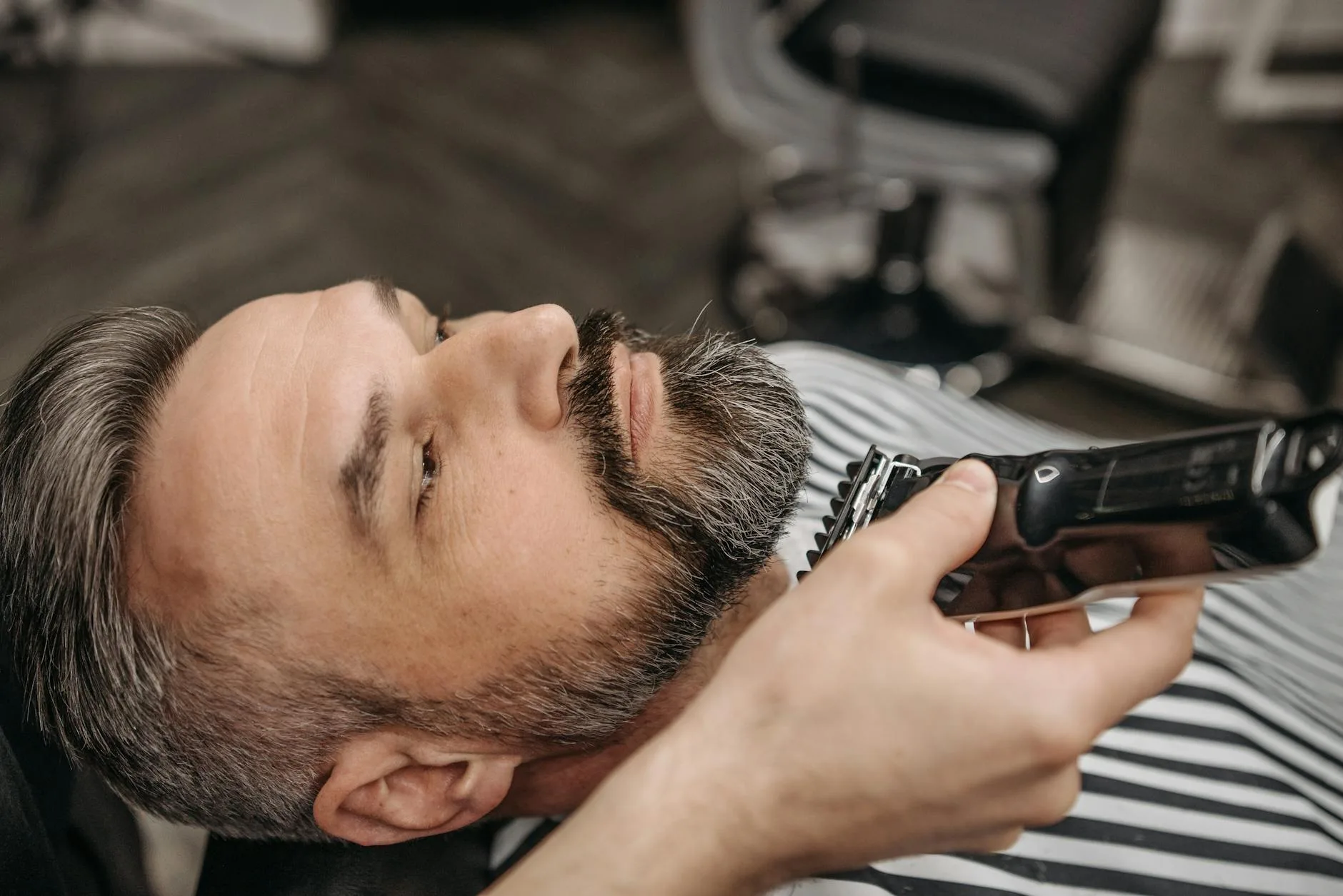 close up shot of a bearded man getting a haircut