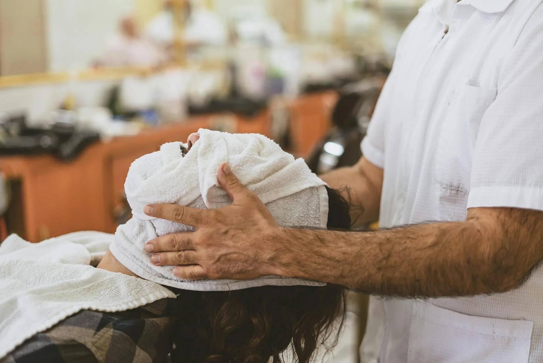 a customer lying down with face towel on the face
